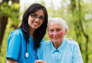 nurse and elderly woman smiling at the camera
