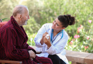 caregiver reminding old man about his medications