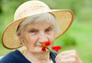 old woman smelling the flower