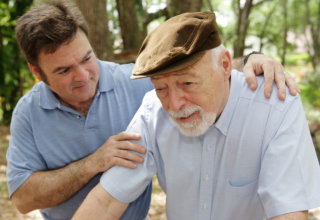 caregiver supporting elderly man on walking