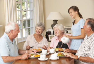 caregiver serving meal to elders